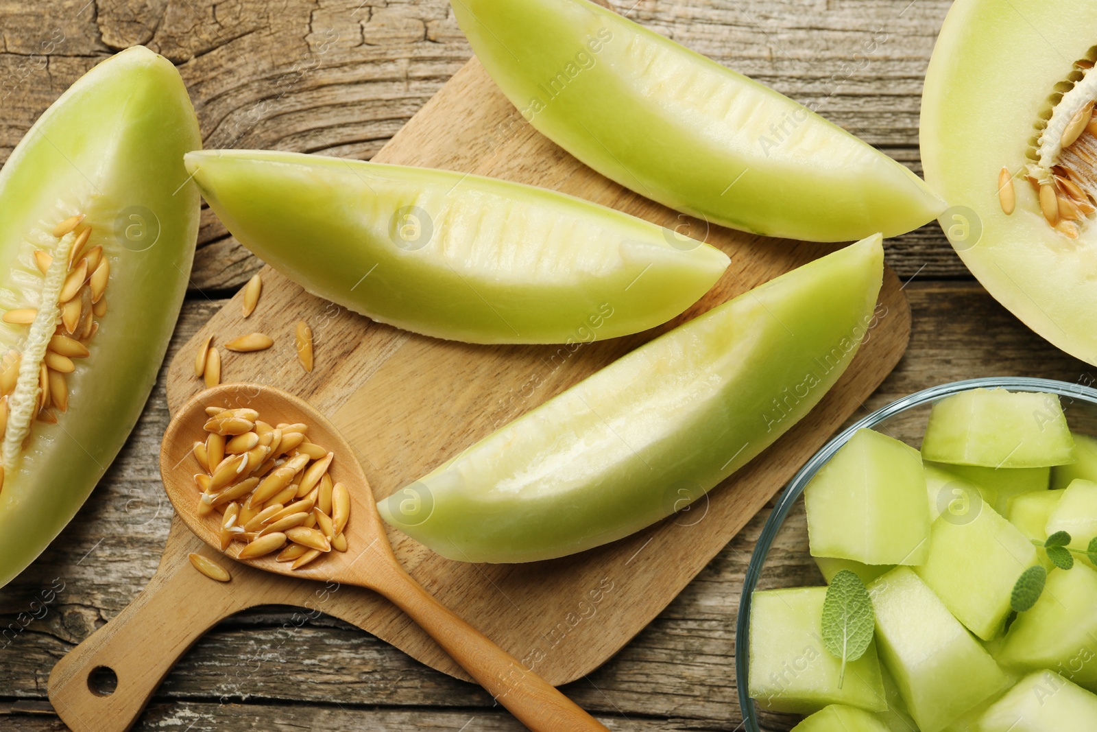 Photo of Slices of yummy melon on wooden table, flat lay