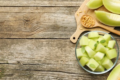 Photo of Slices of yummy melon on wooden table, flat lay. Space for text