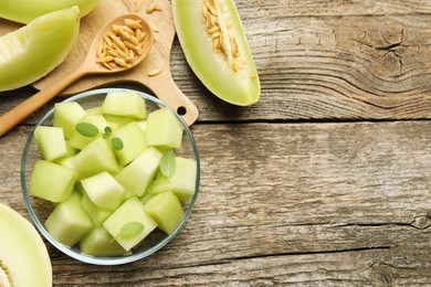 Photo of Slices of yummy melon on wooden table, flat lay. Space for text