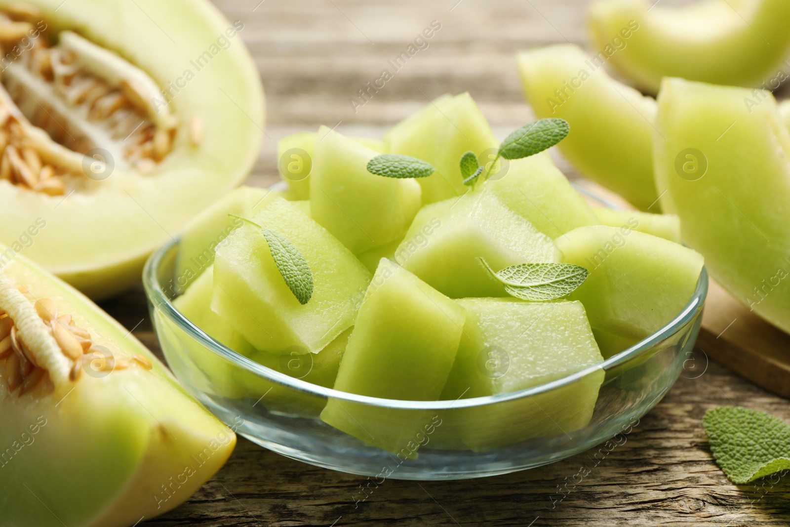 Photo of Slices of yummy melon on wooden table, closeup