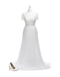 Photo of Mannequin with beautiful wedding dress and shoes isolated on white