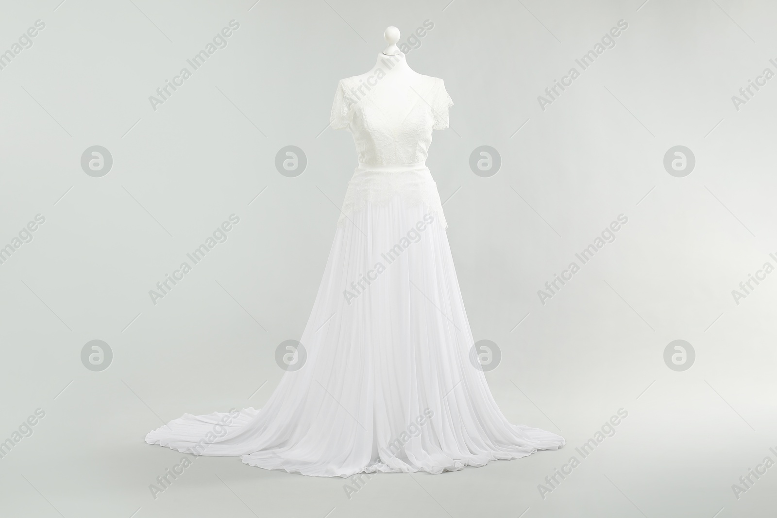 Photo of Mannequin with beautiful wedding dress on light grey background