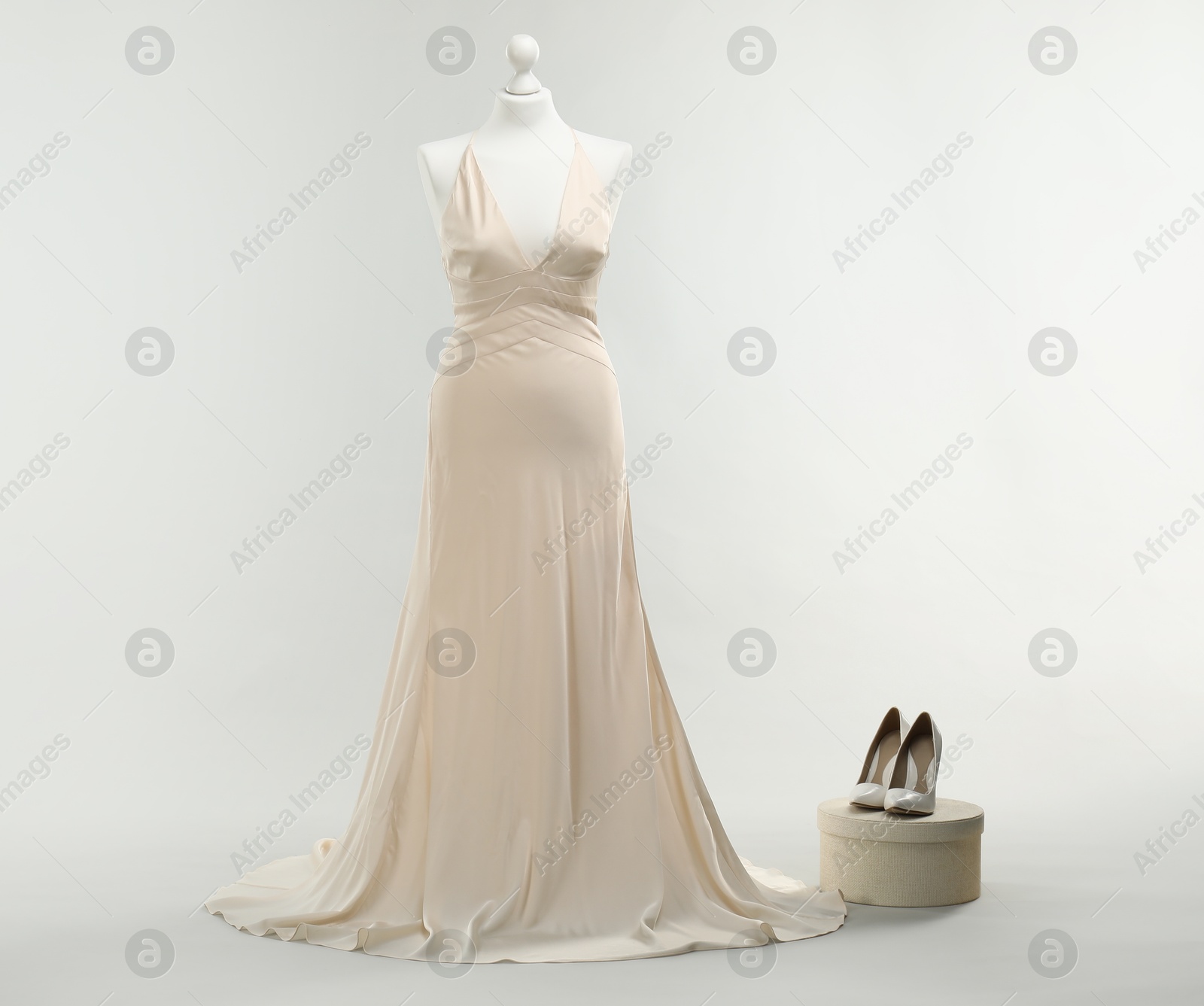 Photo of Mannequin with beautiful wedding dress and shoes on light grey background