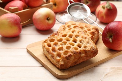 Photo of Delicious puff pastries with apples on white wooden table, closeup