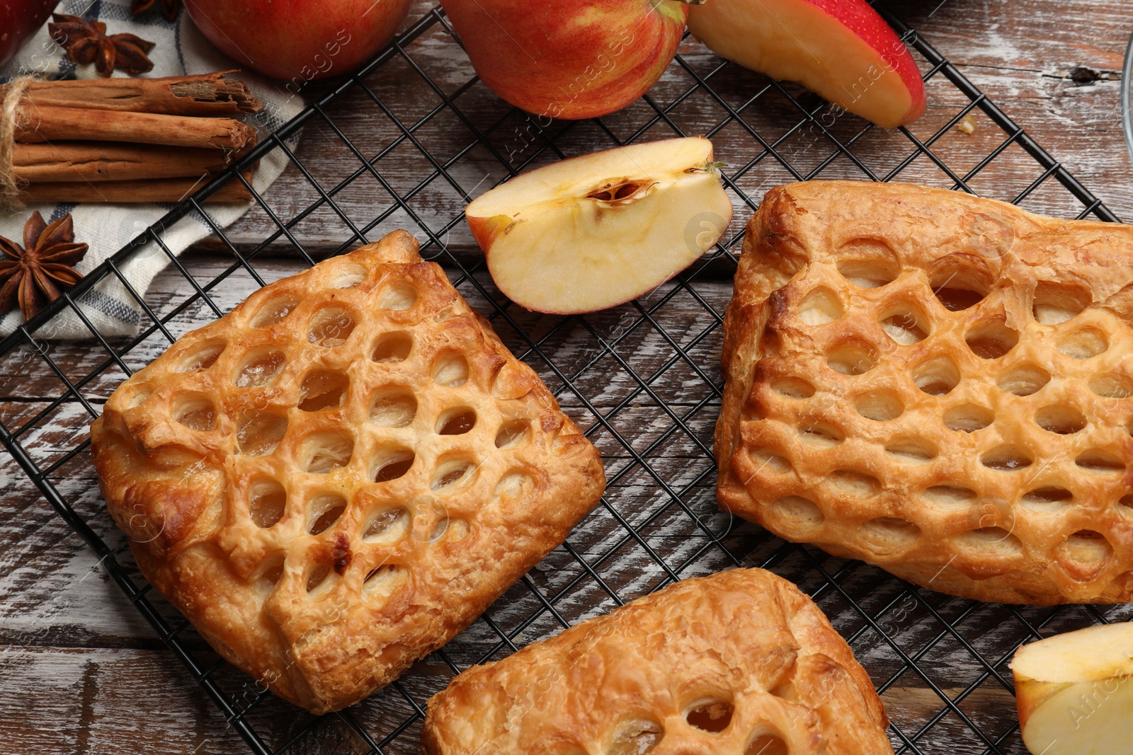 Photo of Delicious puff pastries with fruit filling and apples on wooden table, top view