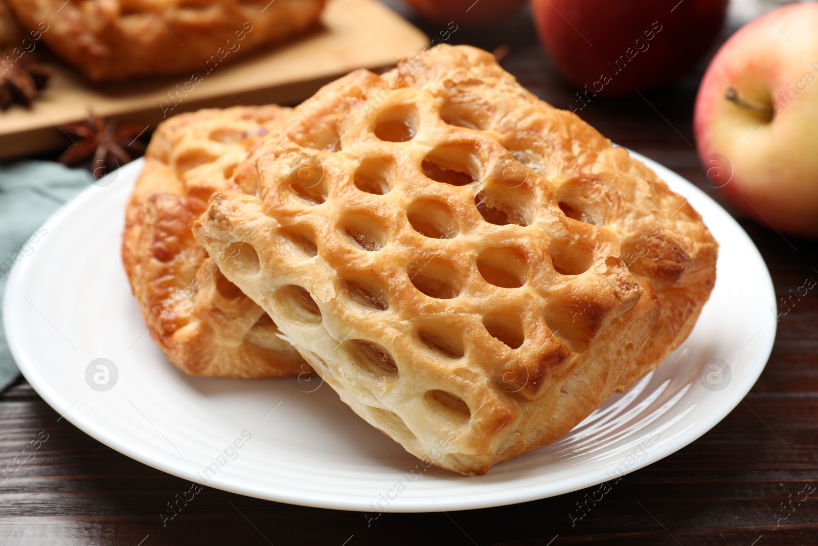 Photo of Delicious puff pastries with fruit filling on wooden table, closeup