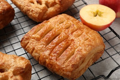 Delicious puff pastries with fruit filling on grey table, closeup