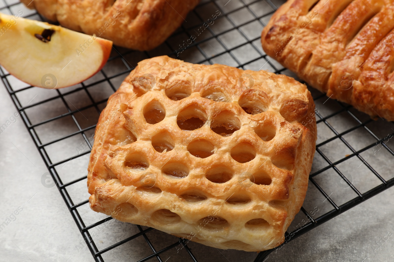 Photo of Delicious puff pastries with fruit filling on grey table, closeup