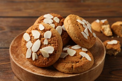 Photo of Tasty cookies with almond flakes on wooden table, closeup