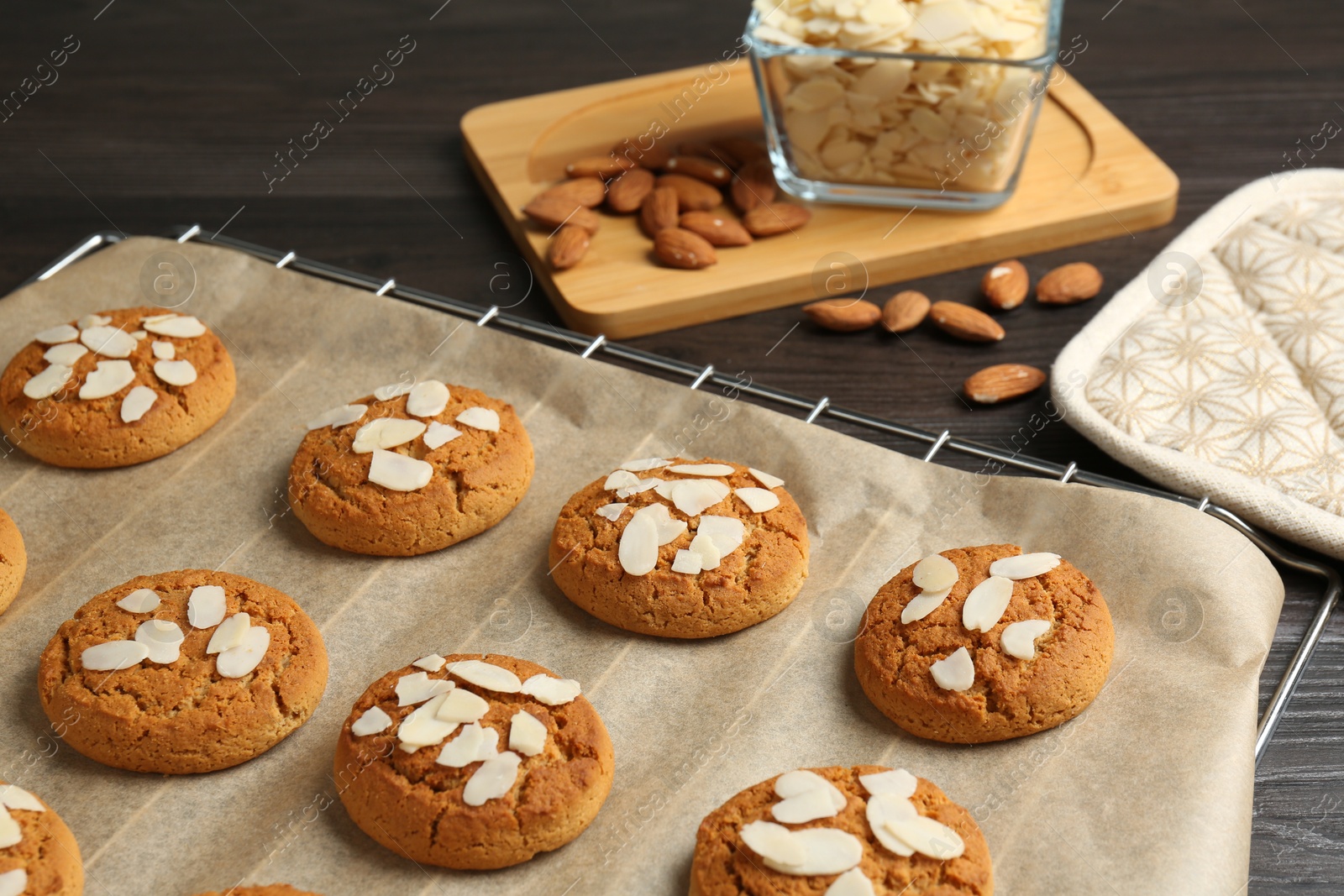 Photo of Tasty cookies with almond flakes and nuts on wooden table