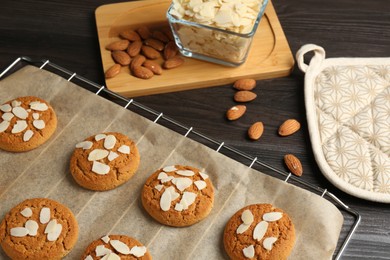 Photo of Tasty cookies with almond flakes and nuts on wooden table