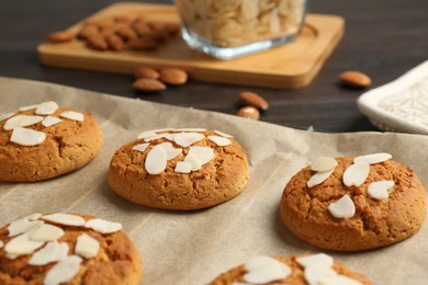 Photo of Tasty cookies with almond flakes on table, closeup