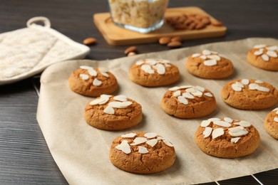 Photo of Tasty cookies with almond flakes on wooden table, closeup