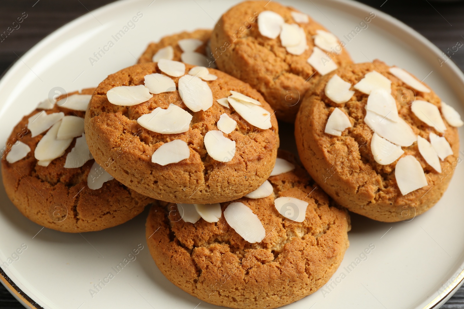 Photo of Tasty cookies with almond flakes on table, closeup