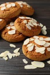 Photo of Tasty cookies with almond flakes on wooden table, closeup