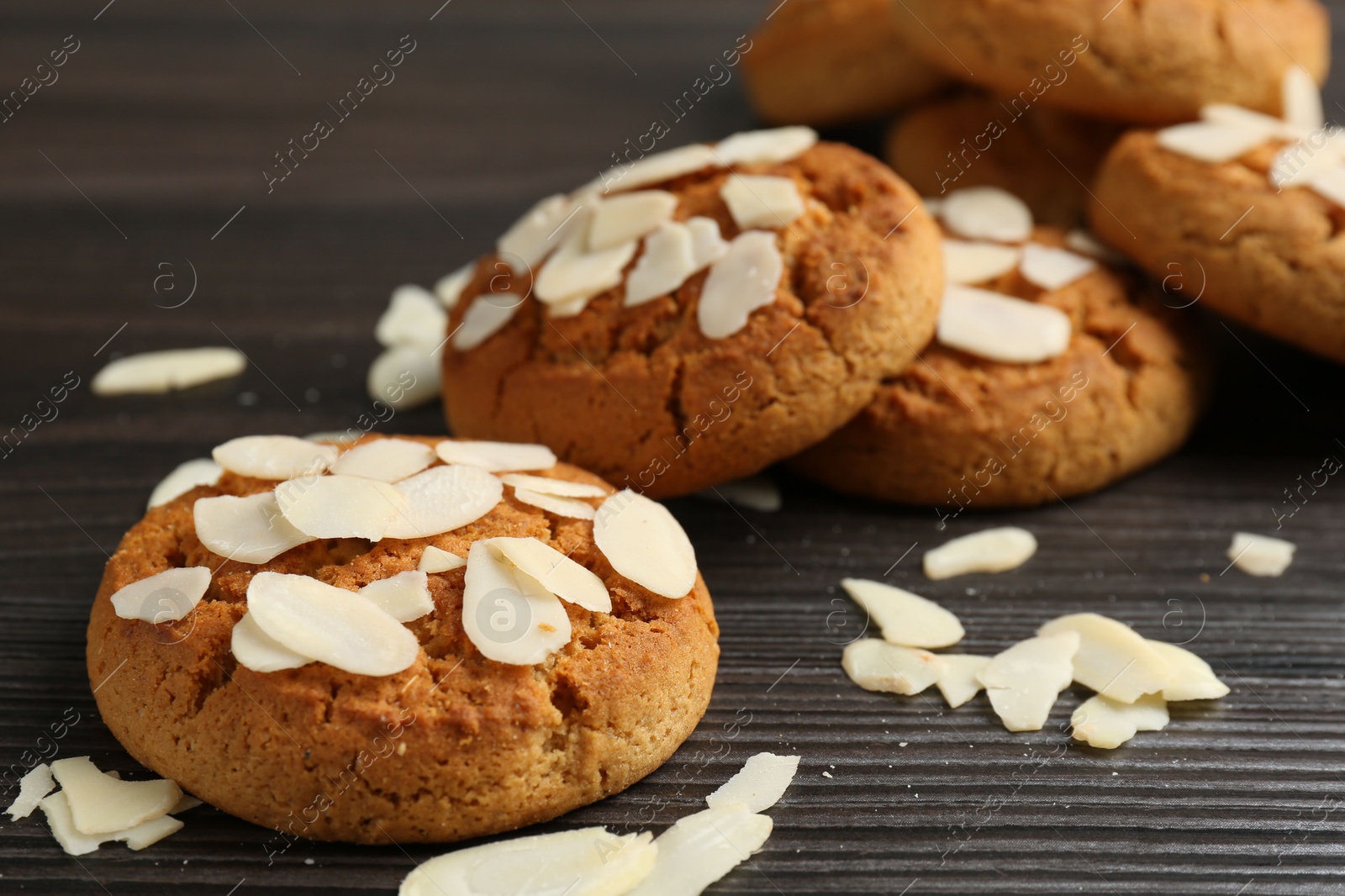 Photo of Tasty cookies with almond flakes on wooden table, closeup