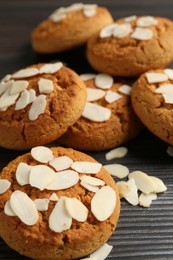 Photo of Tasty cookies with almond flakes on wooden table, closeup