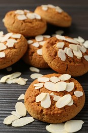 Photo of Tasty cookies with almond flakes on wooden table, closeup