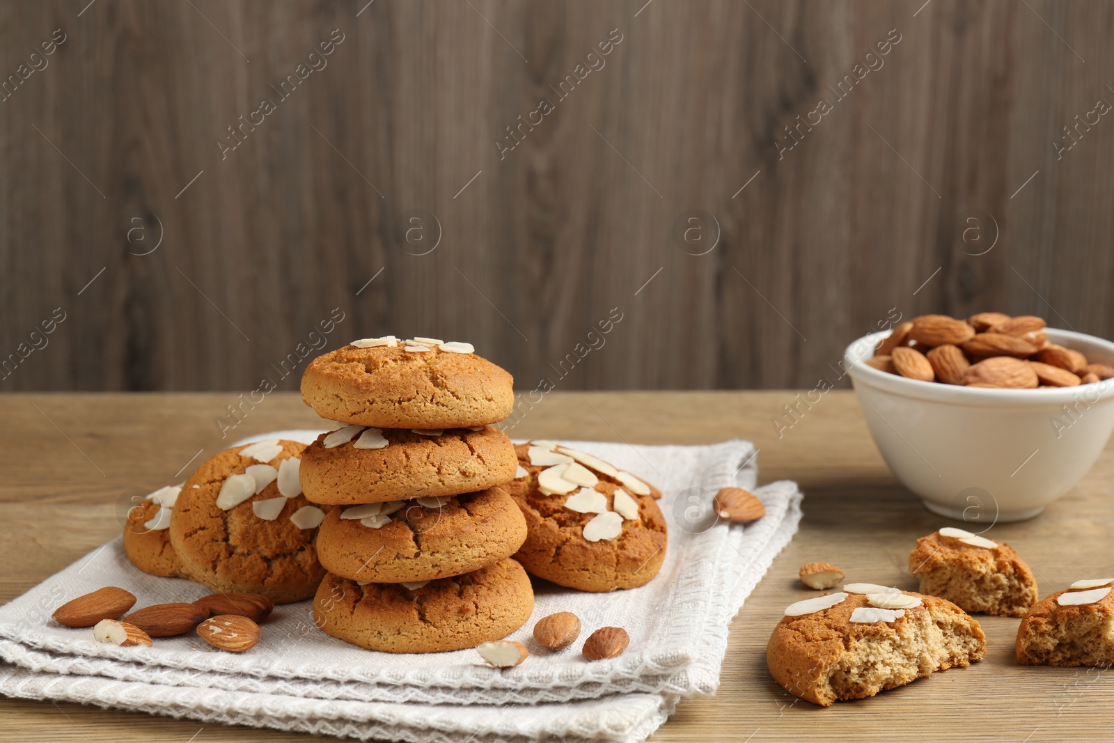 Photo of Tasty cookies with almond flakes and nuts on wooden table