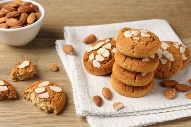 Photo of Tasty cookies with almond flakes and nuts on wooden table, closeup