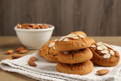 Photo of Tasty cookies with almond flakes and nuts on wooden table, closeup