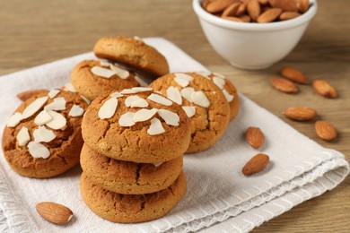 Photo of Tasty cookies with almond flakes and nuts on wooden table, closeup