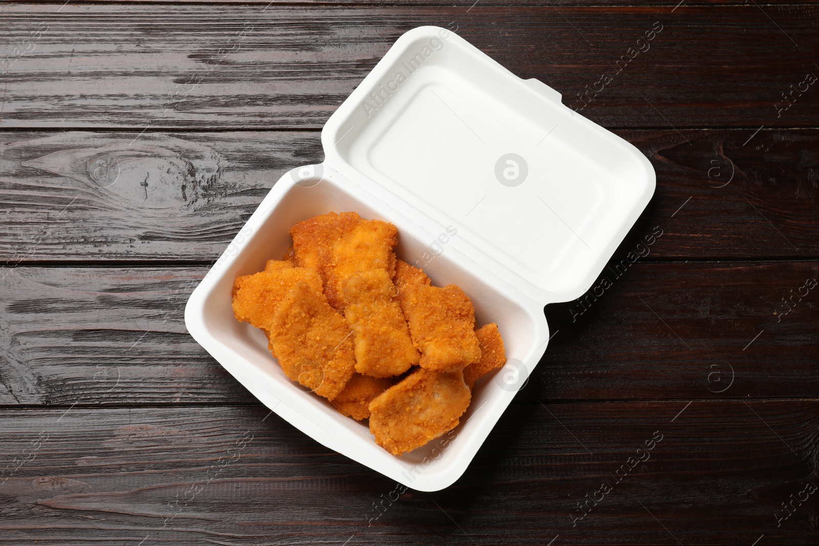 Photo of Tasty chicken nuggets on wooden table, top view