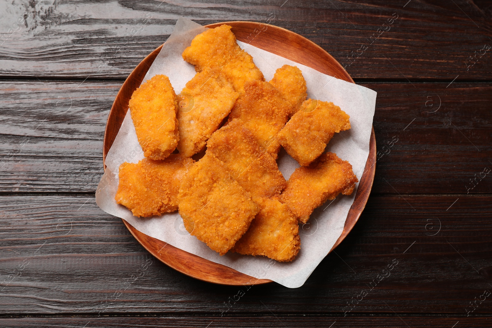 Photo of Tasty chicken nuggets on wooden table, top view