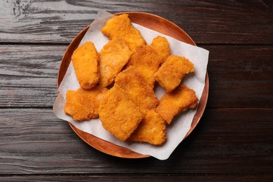 Photo of Tasty chicken nuggets on wooden table, top view