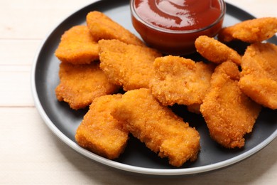 Photo of Tasty chicken nuggets and sauce on wooden table, closeup