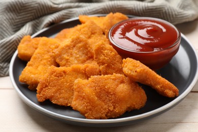 Photo of Tasty chicken nuggets and sauce on wooden table, closeup