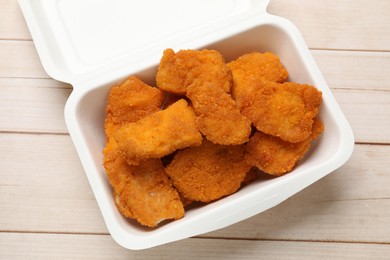 Photo of Tasty chicken nuggets on wooden table, top view