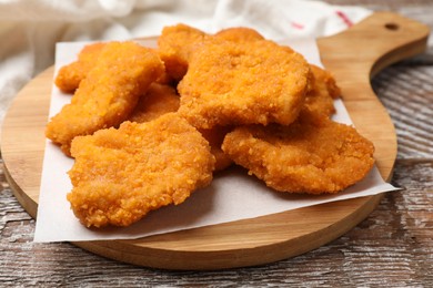 Photo of Delicious chicken nuggets on wooden table, closeup