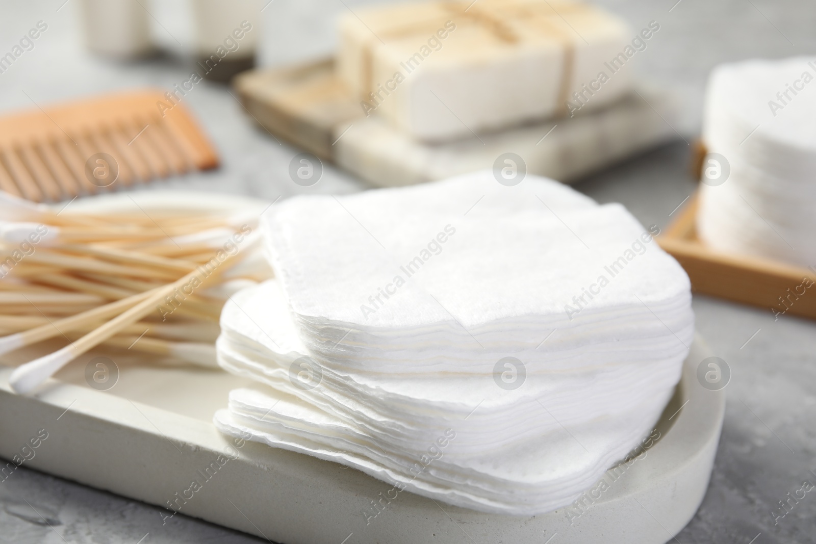 Photo of Clean cotton pads and swabs on grey table, closeup