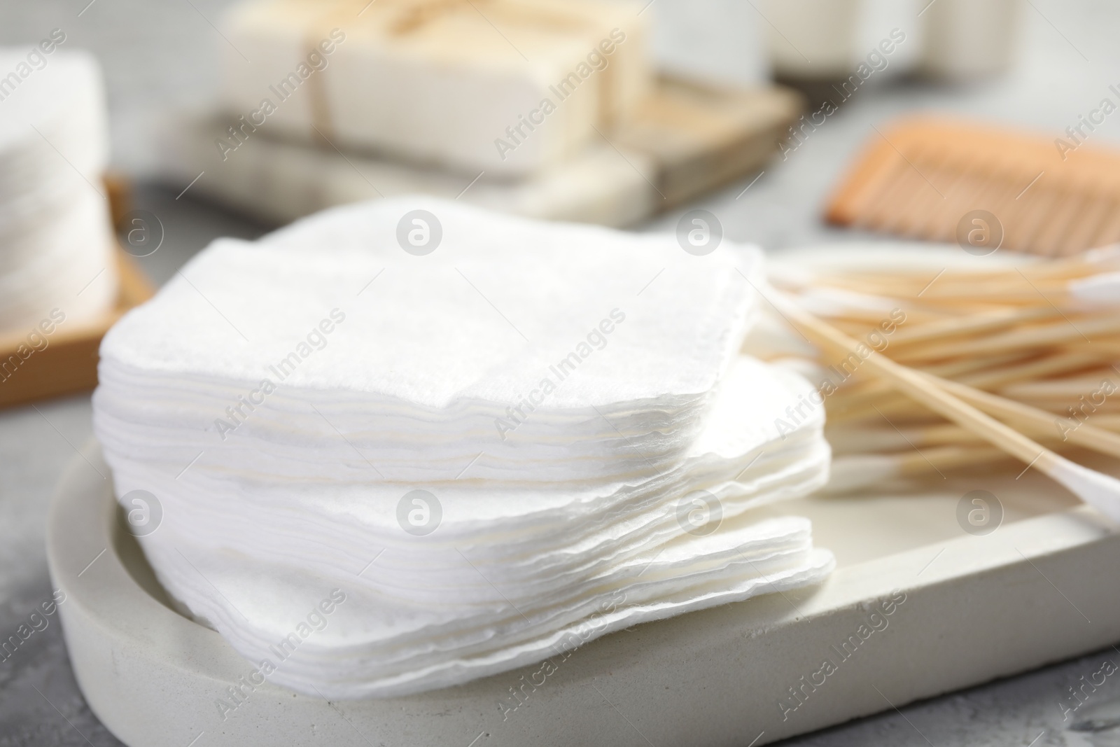 Photo of Clean cotton pads and swabs on grey table, closeup