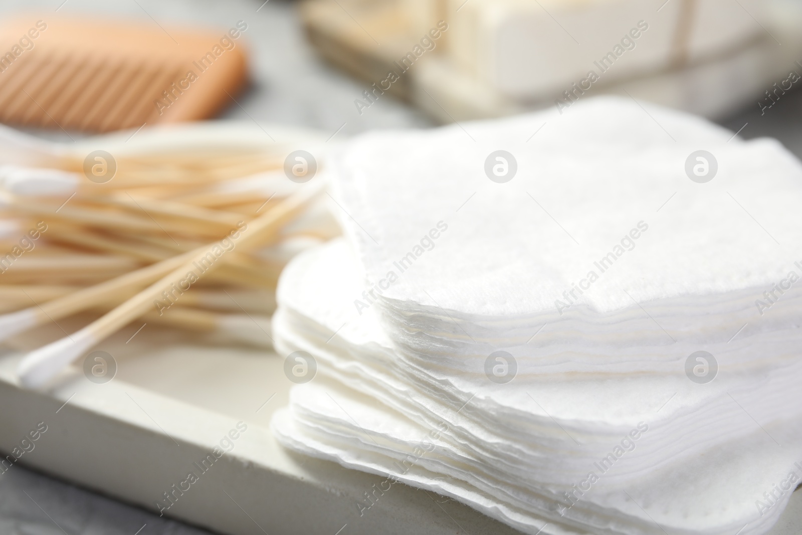 Photo of Clean cotton pads and swabs on grey table, closeup