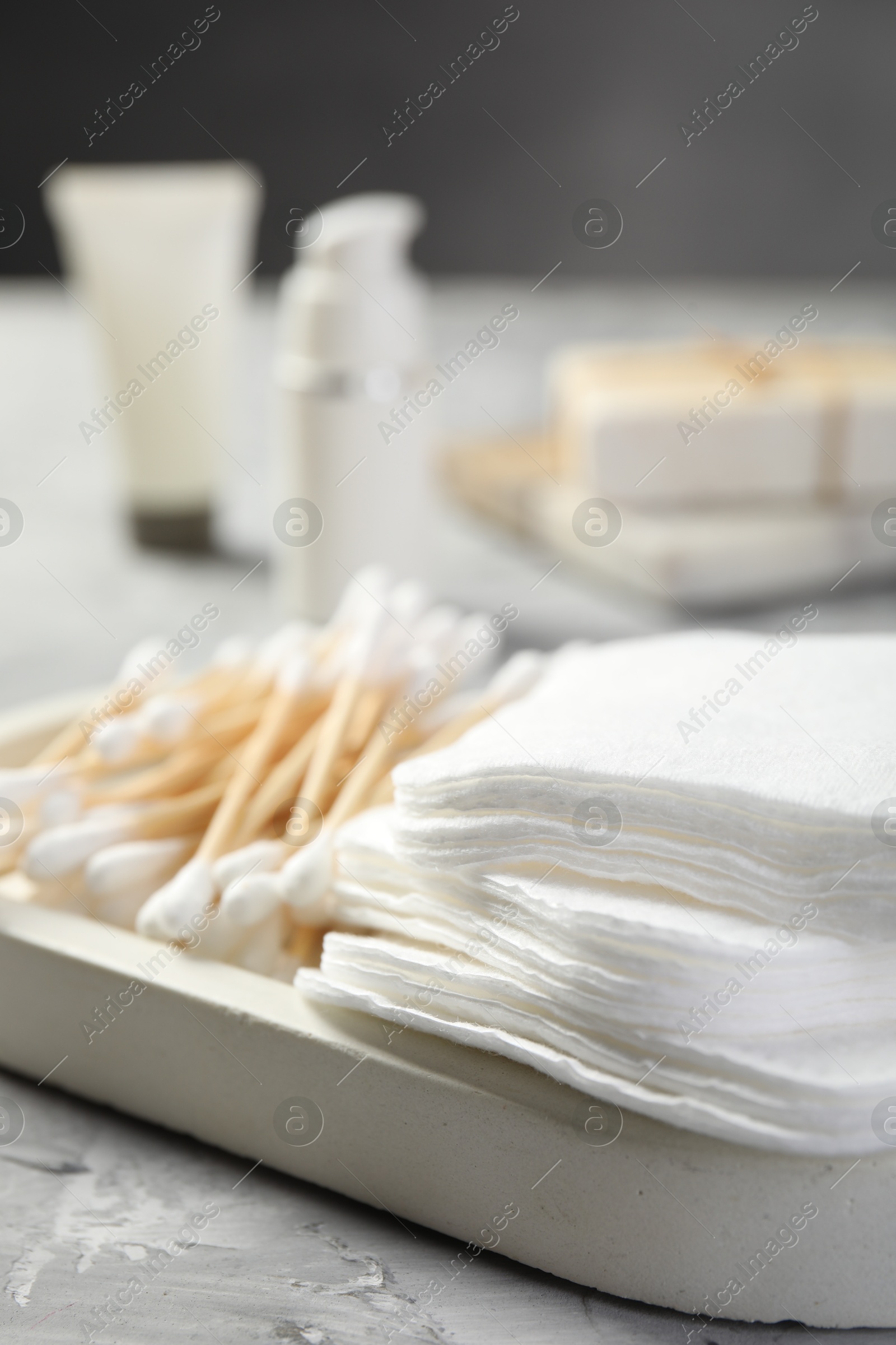 Photo of Clean cotton pads and swabs on grey table, closeup