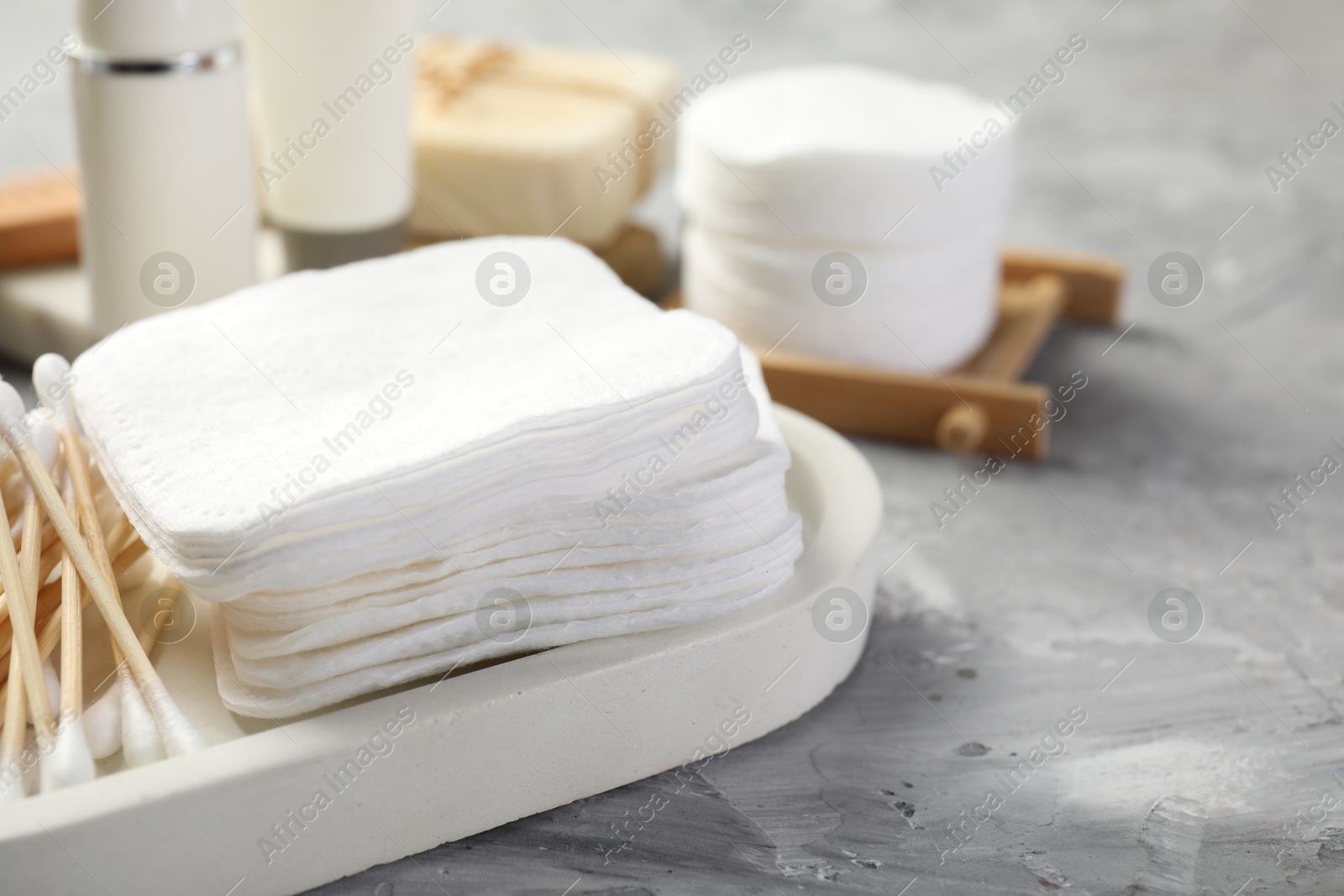 Photo of Clean cotton pads and swabs on grey table, closeup