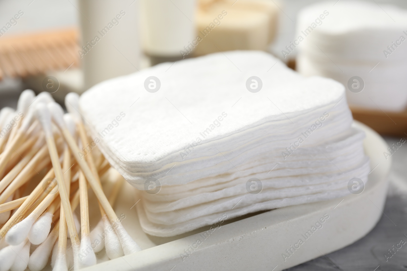 Photo of Clean cotton pads and swabs on grey table, closeup