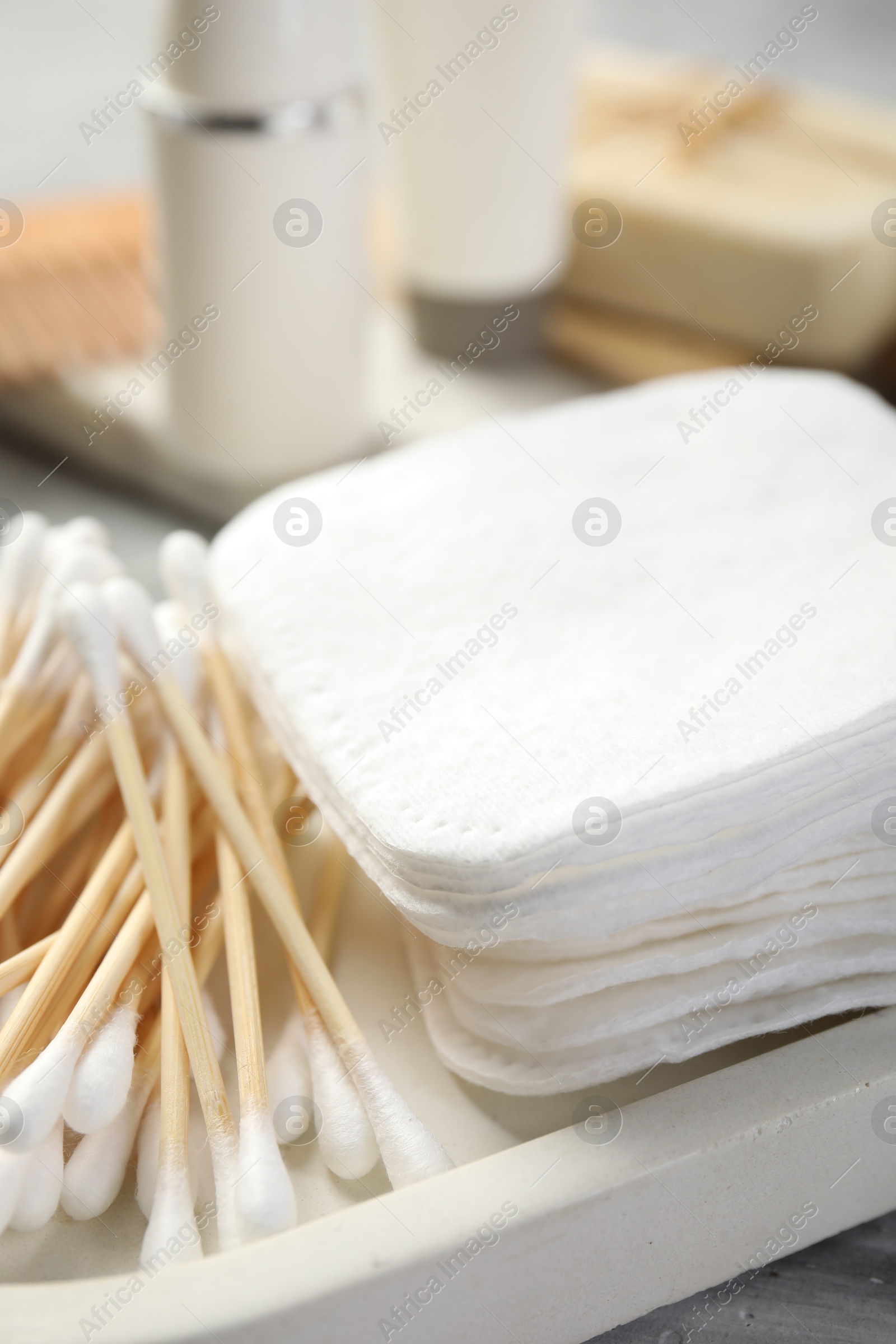 Photo of Clean cotton pads and swabs on grey table, closeup