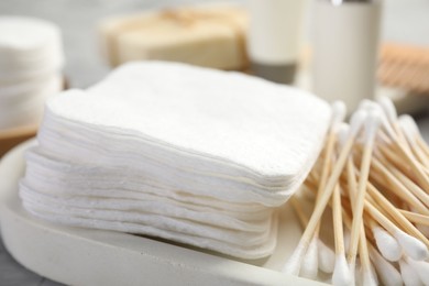 Photo of Clean cotton pads and swabs on grey table, closeup