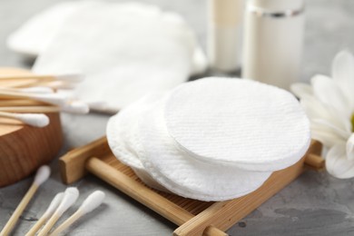 Photo of Clean cotton pads and swabs on grey table, closeup