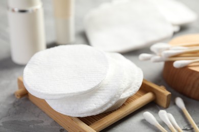 Photo of Clean cotton pads and swabs on grey table, closeup