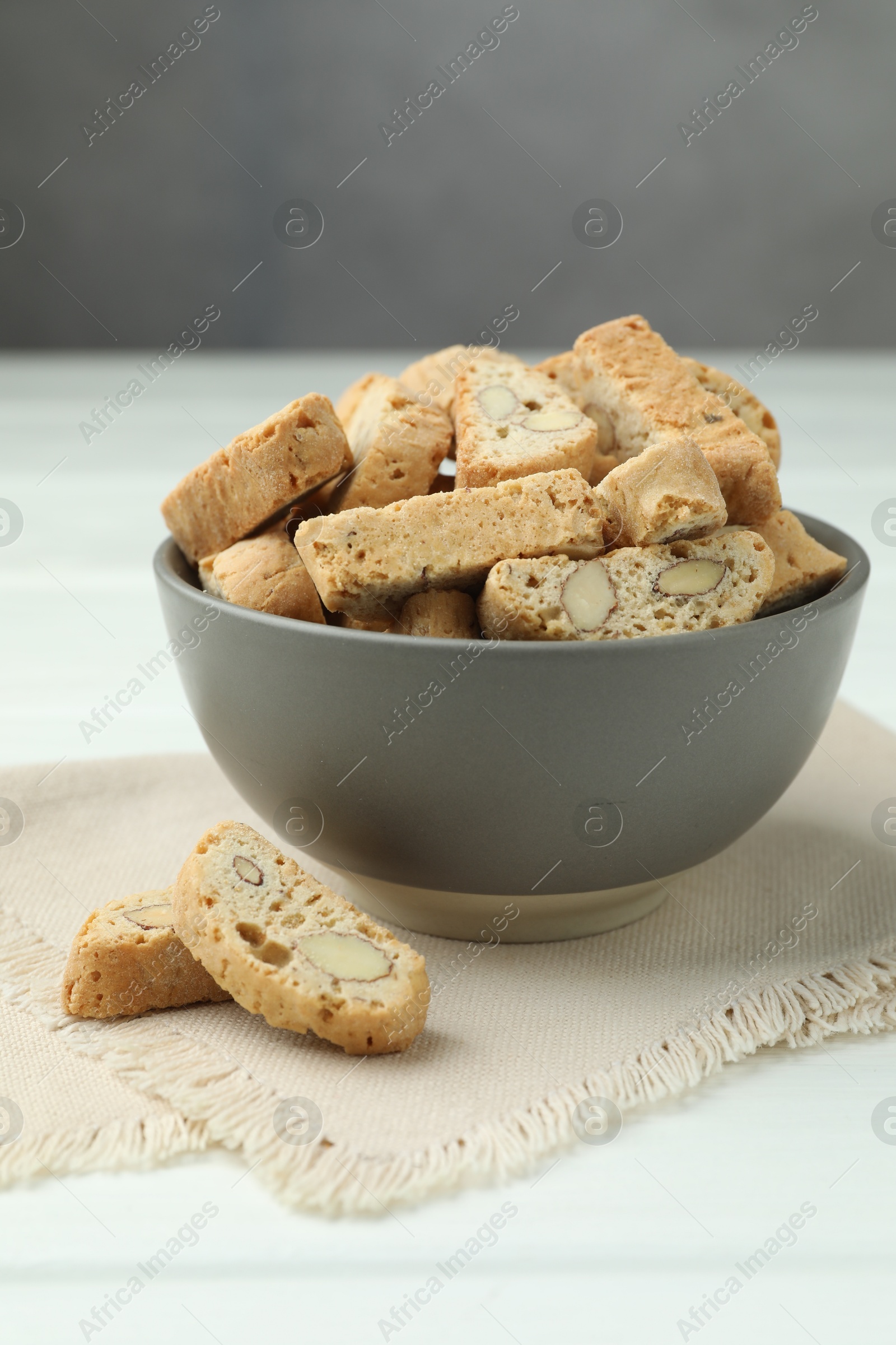 Photo of Traditional Italian almond biscuits (Cantucci) in bowl on white table