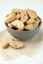 Photo of Traditional Italian almond biscuits (Cantucci) in bowl on white table, closeup