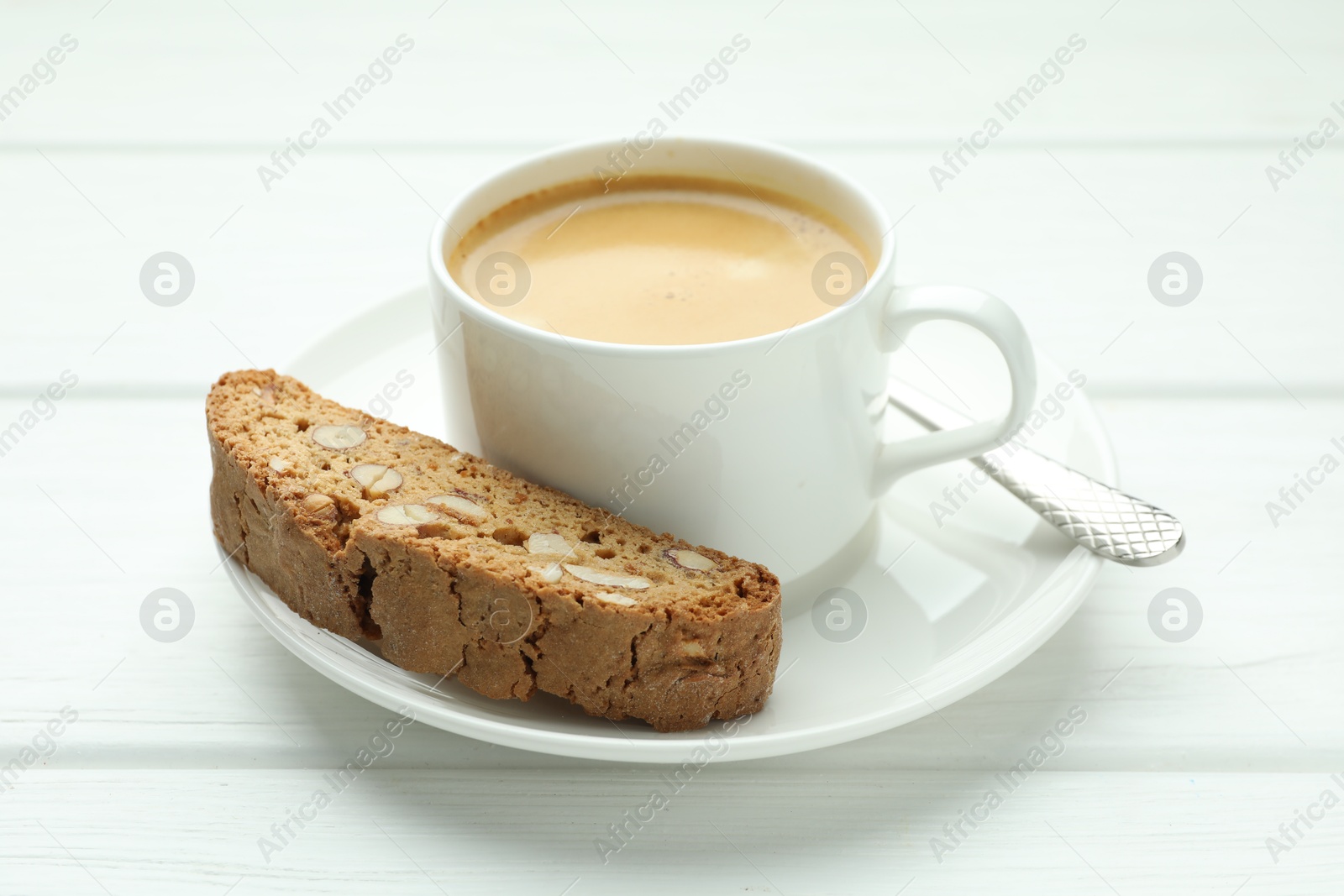 Photo of Traditional Italian almond biscuit (Cantucci) and coffee on white wooden table, closeup