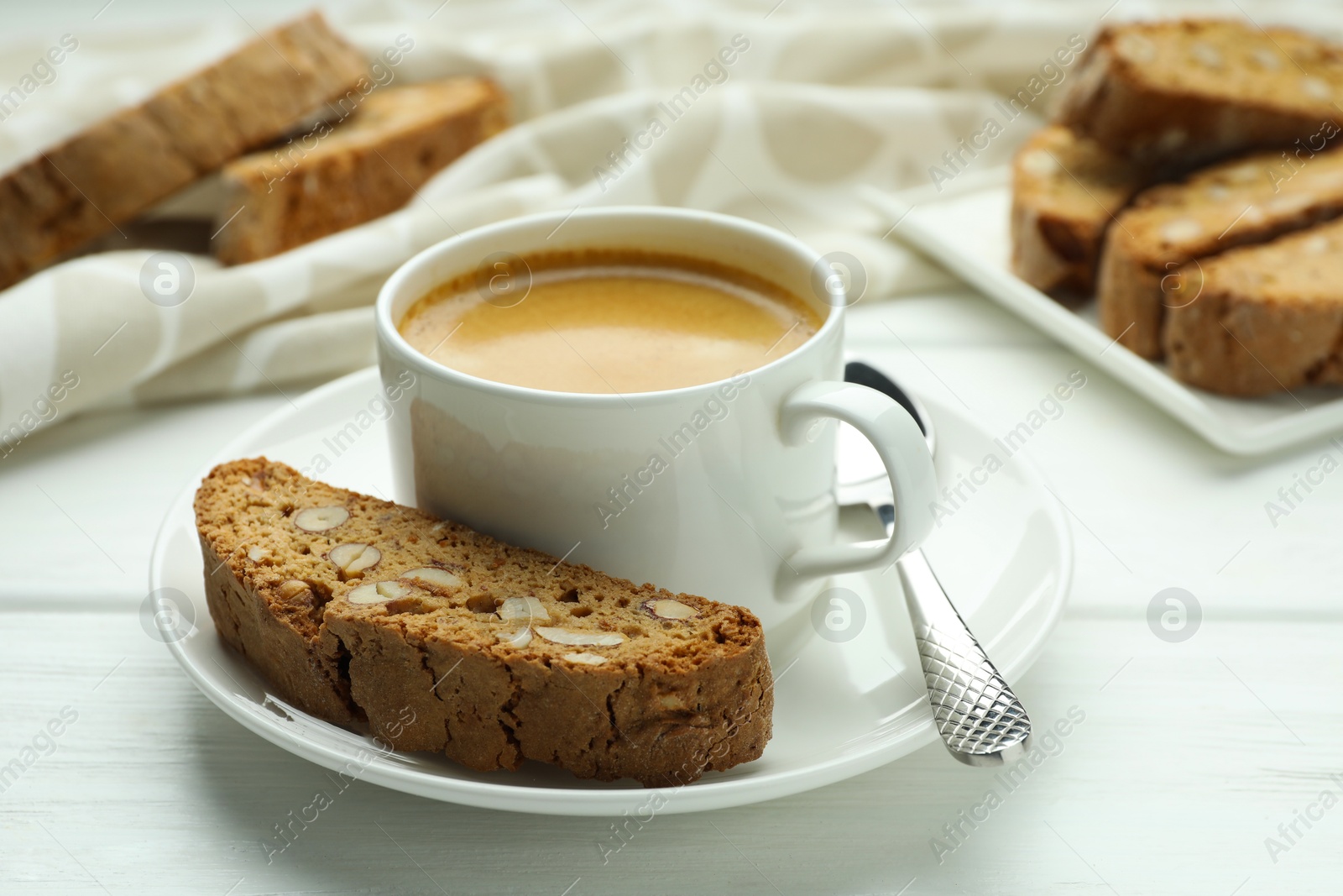 Photo of Traditional Italian almond biscuits (Cantucci) and coffee on white wooden table, closeup