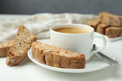 Photo of Traditional Italian almond biscuits (Cantucci) and coffee on white table, closeup