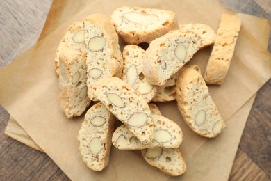 Traditional Italian almond biscuits (Cantucci) and nuts on wooden table, top view