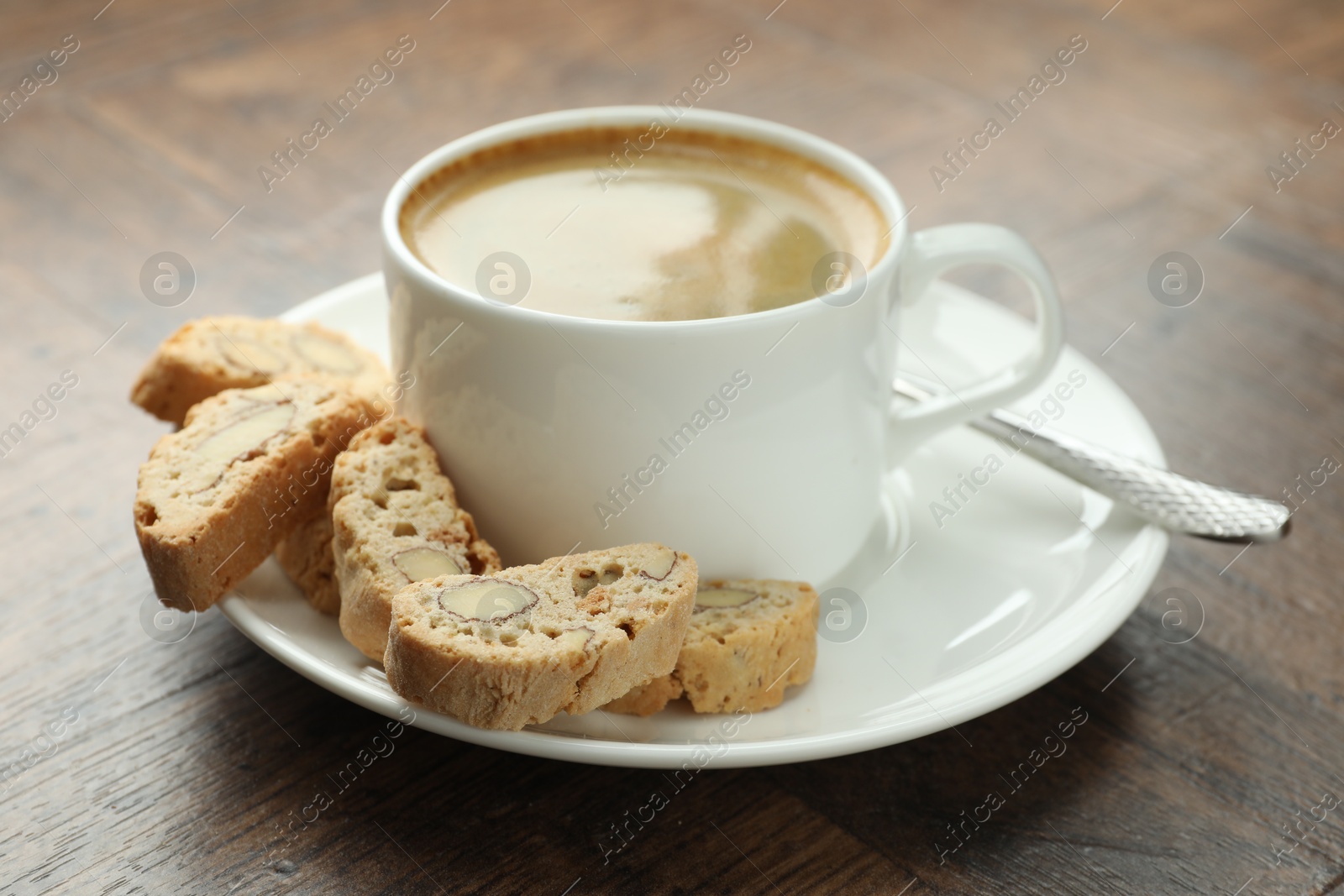 Photo of Traditional Italian almond biscuits (Cantucci) and coffee on wooden table, closeup